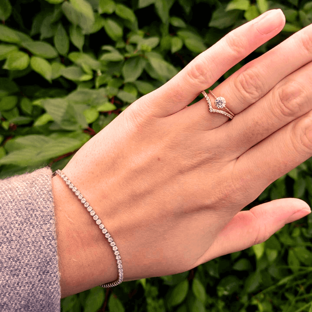woman wearing gold and diamond eternity ring and solitaire ring
