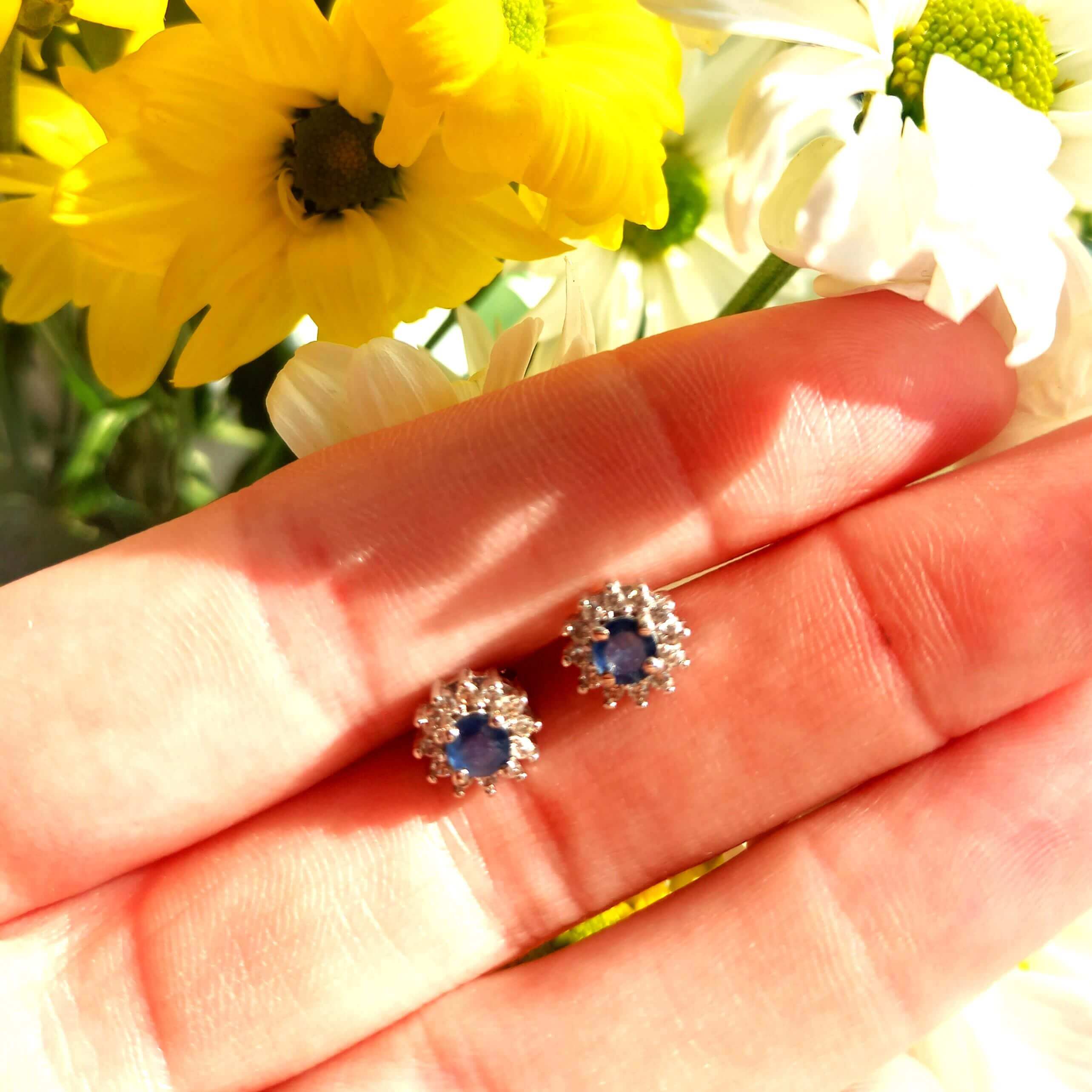 silver blue sapphire and cz halo earrings on a floral background